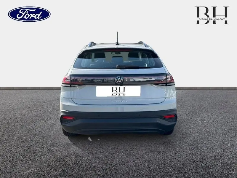 Vue arrière d'un Volkswagen Taigo blanc pur 2024 avec feux arrière LED reliés par une bande noire brillante.