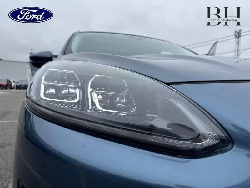 Gros plan sur le phare avant gauche du Ford Kuga 2022 en Bleu Azur Métallisée avec détails LED distinctifs.