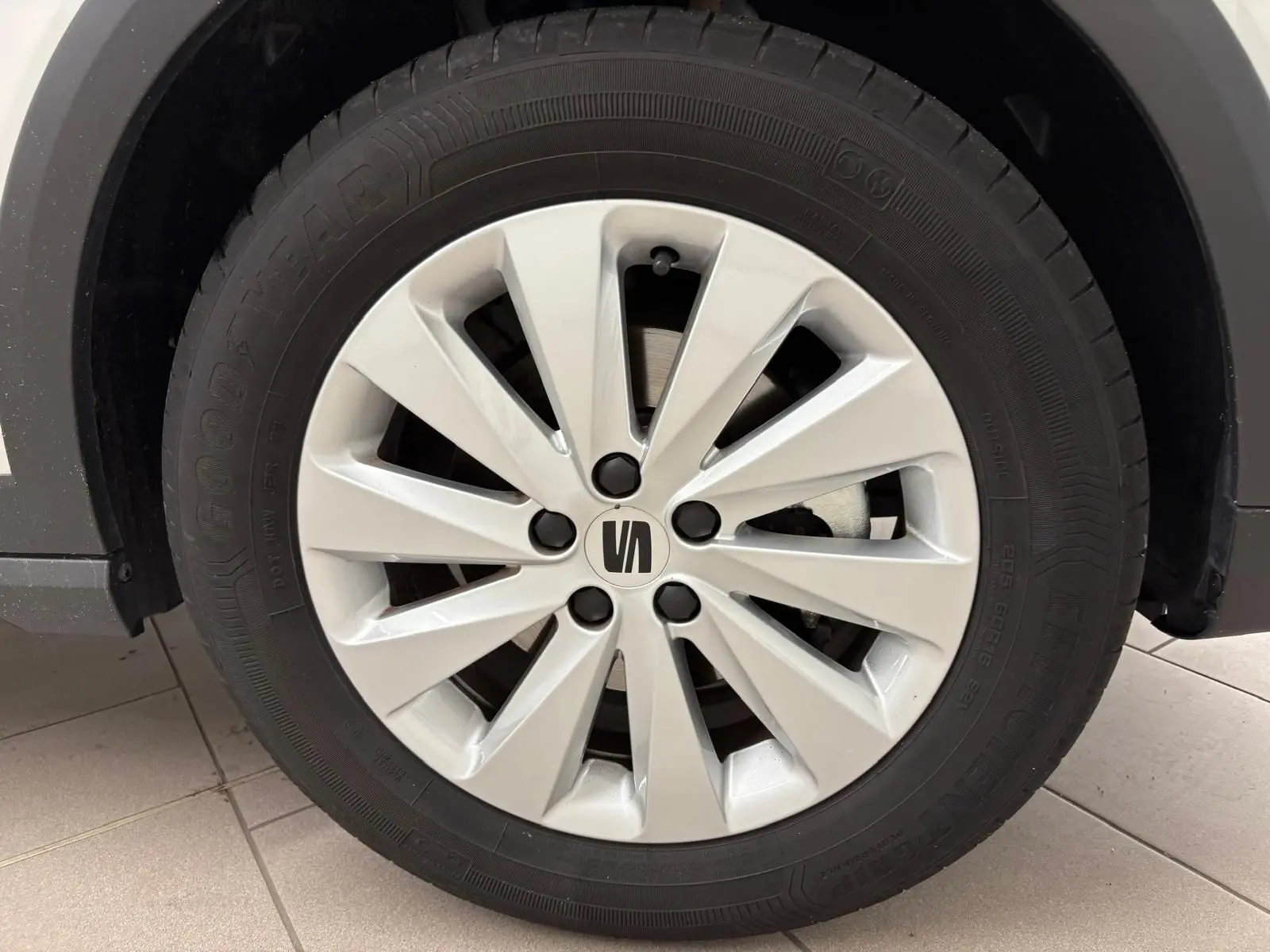 Gros plan sur la roue avant gauche du SEAT Arona blanc avec jante argentée et pneu Goodyear.