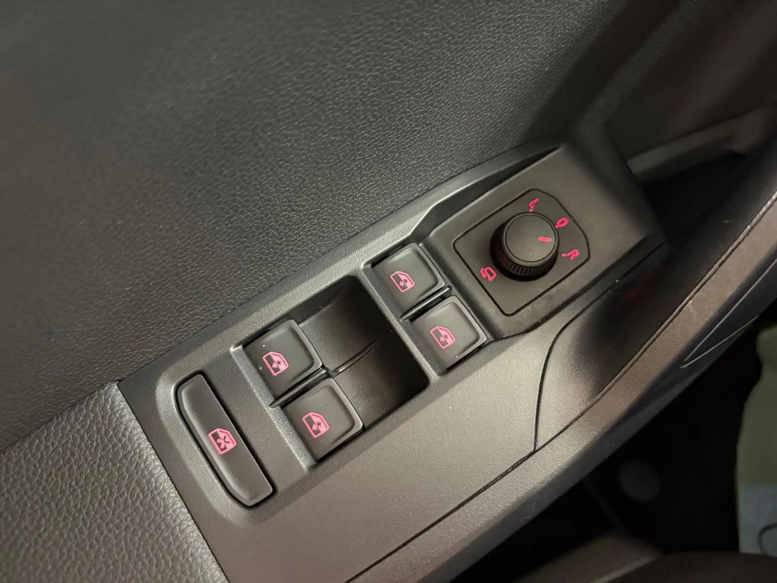 Gros plan sur les commandes de lève-vitres et réglage des rétroviseurs côté conducteur du SEAT Arona blanc toit noir 2023.