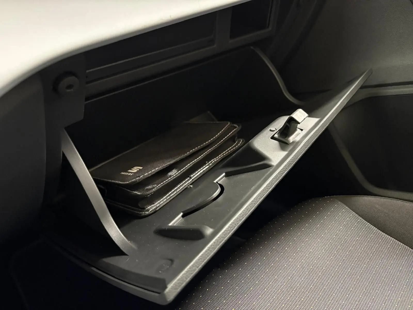 Gant de boîte à gants ouvert avec manuel SEAT visible, intérieur noir du SEAT Arona 2023 côté passager.