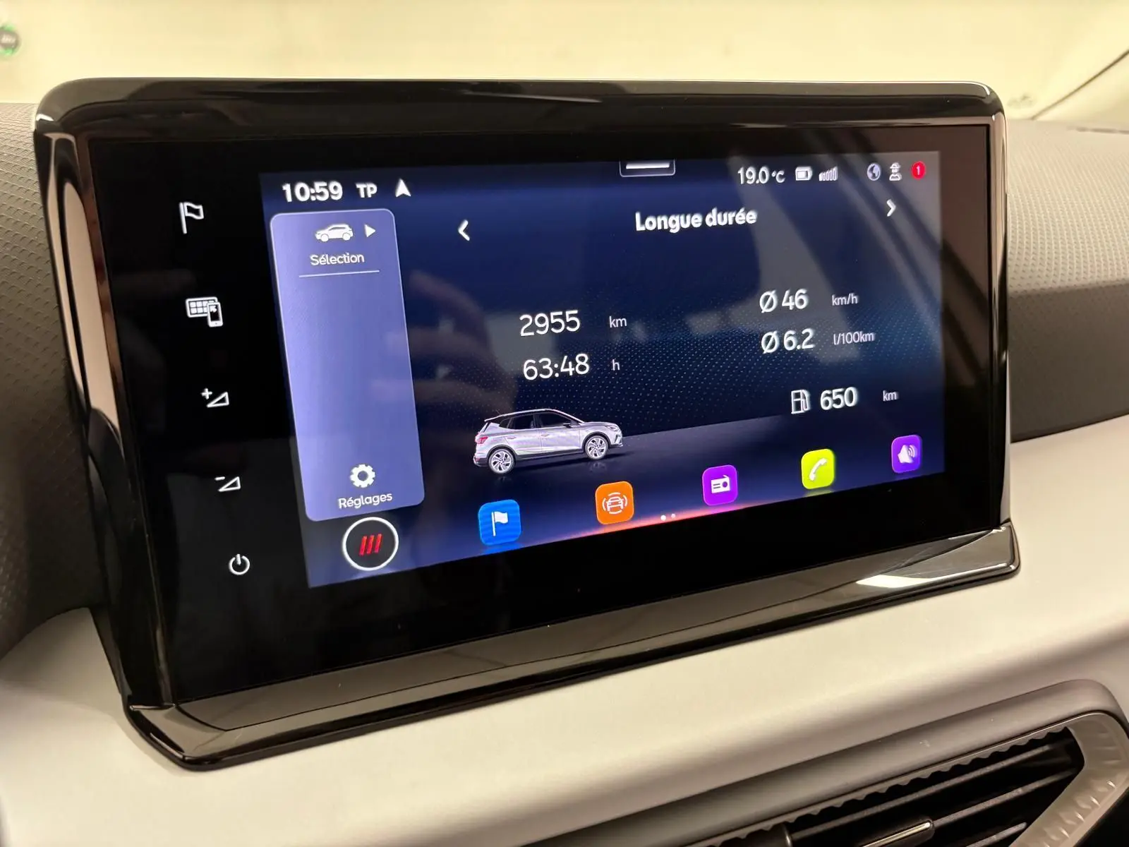 Écran tactile central du tableau de bord du SEAT Arona blanc toit noir, affichant les données de conduite longue durée.