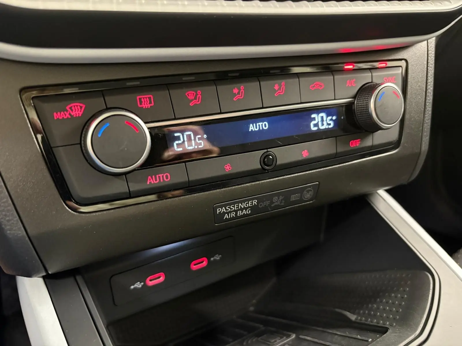 Détail du tableau de bord de la SEAT Arona 2023 montrant la climatisation automatique avec affichage digital et commandes rouges.