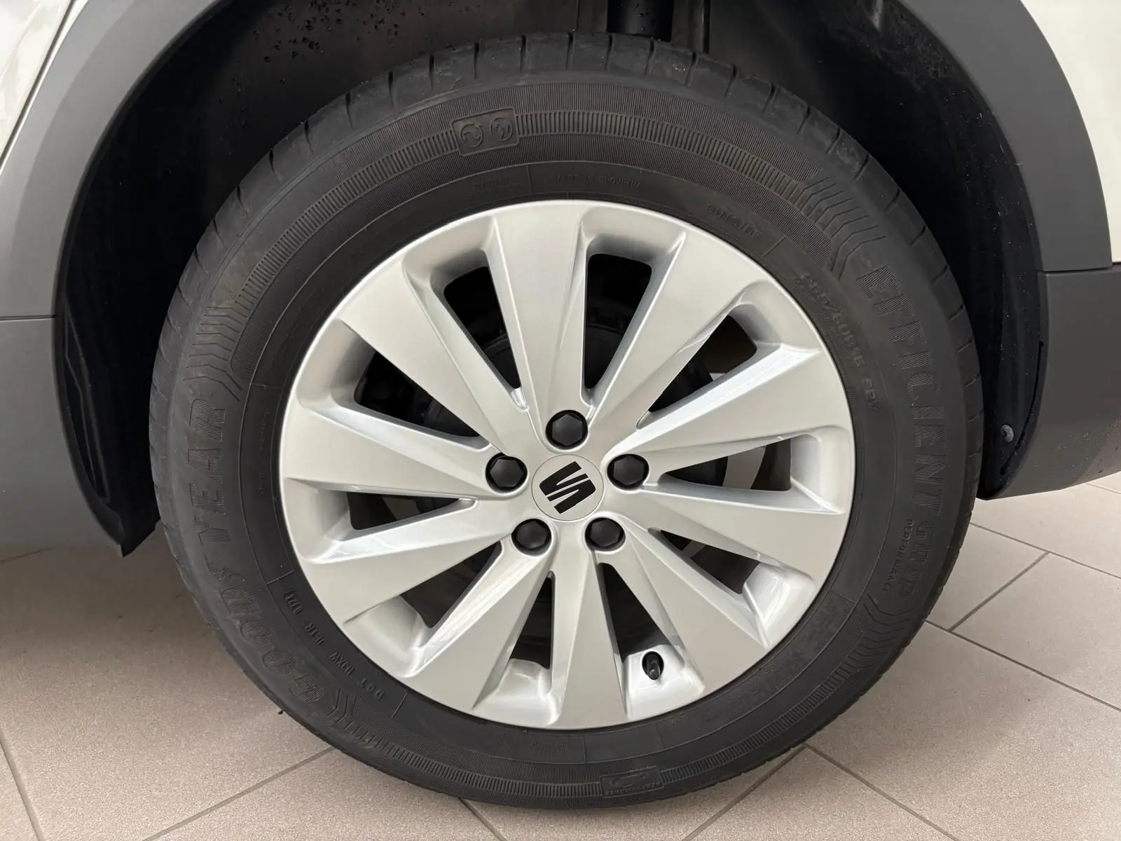Gros plan sur la roue avant gauche d'une SEAT Arona 2023 blanche avec jante alliage et logo central noir.