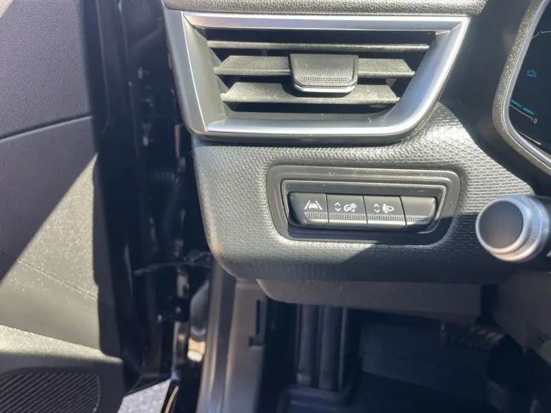 Détail des commandes d'assistance au conducteur sur la gauche du tableau de bord d'une Renault Clio noir étoile 2020.