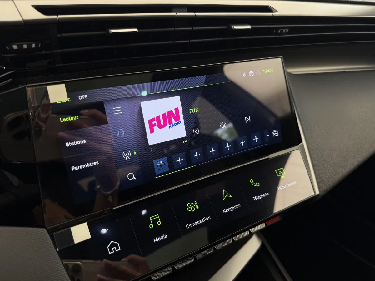 Écran tactile central de la Peugeot 308 Hybrid GT 2024 affichant la radio Fun, vue intérieure côté passager.