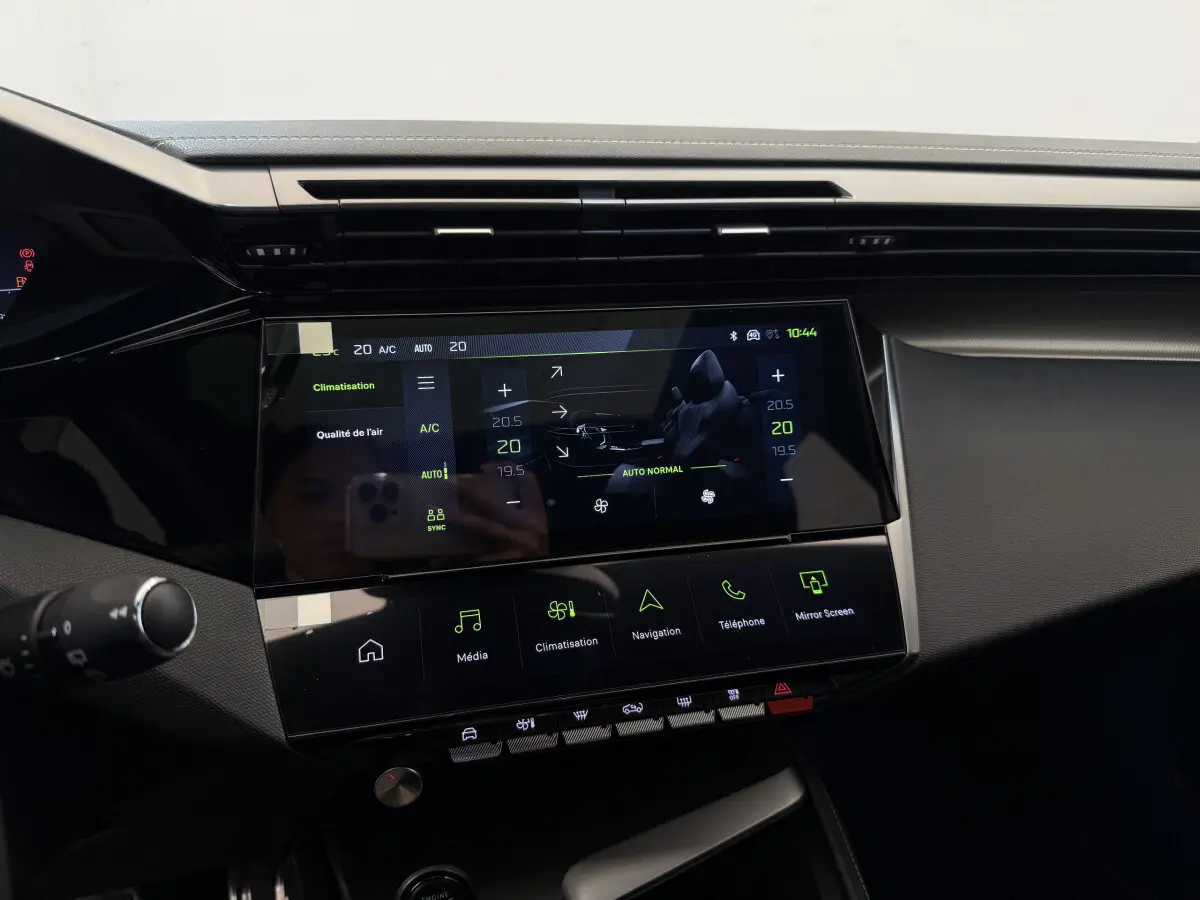 Tableau de bord central tactile de la Peugeot 308 Hybrid 136 e-DCS6 GT 2024, affichage climatisation et multimédia.