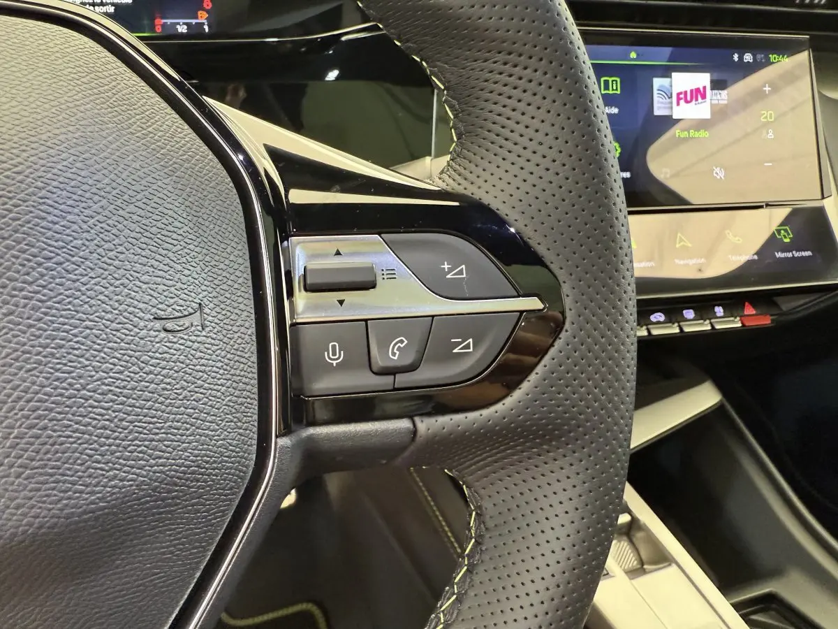 Gros plan sur le volant cuir perforé et les commandes multifonctions du Peugeot 308 Hybrid 136 e-DCS6 GT 2024.