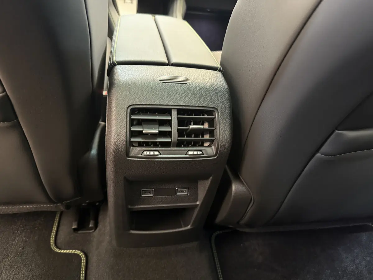 Vue rapprochée des aérateurs arrière et ports USB entre les sièges noirs de la Peugeot 308 Hybrid 136 e-DCS6 GT 2024.