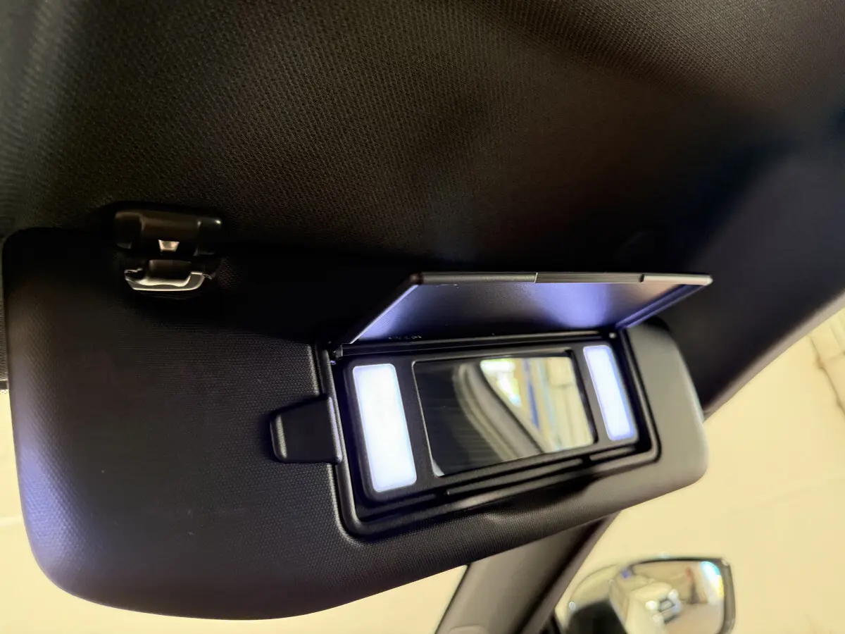 Miroir de courtoisie éclairé sur pare-soleil côté conducteur dans l’habitacle d’une Peugeot 308 Hybrid blanc 2024.