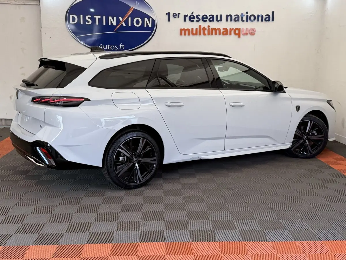 Peugeot 308 Hybrid 136 e-DCS6 GT blanc vue de profil côté droit avec jantes noires et toit noir contrasté.