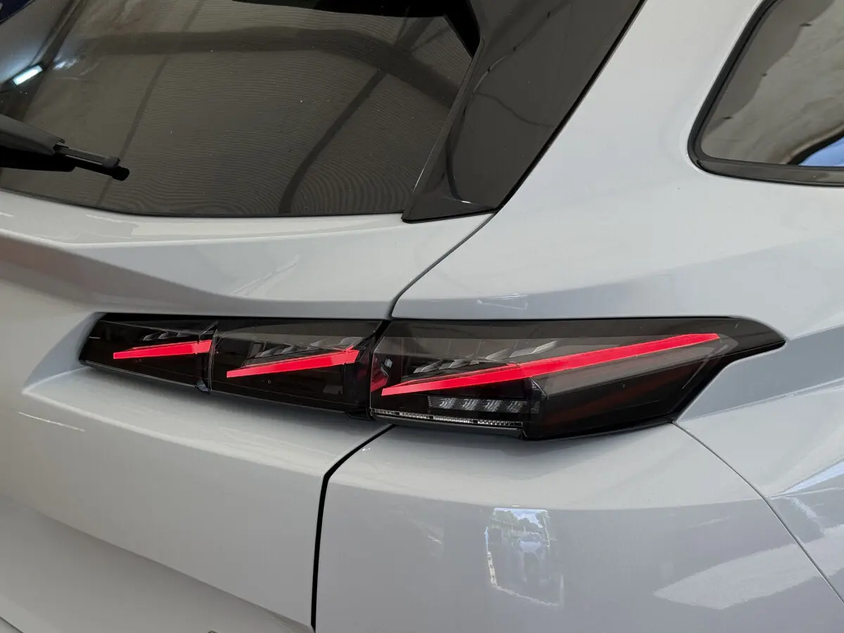 Gros plan sur le feu arrière droit rouge et noir d'une Peugeot 308 Hybrid 136 e-DCS6 GT blanche de 2024.