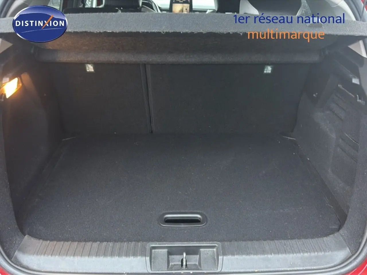 Coffre ouvert vu de face du Renault Captur rouge flamme, montrant un espace de chargement propre et vide.