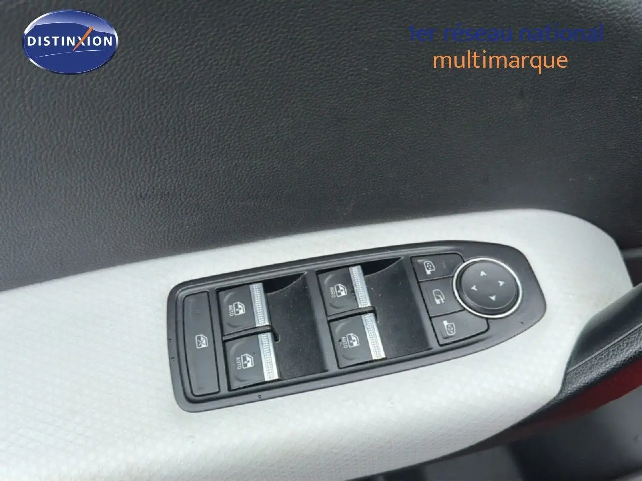 Gros plan sur les commandes des vitres électriques et rétroviseurs côté conducteur du Renault Captur rouge flamme 2020.