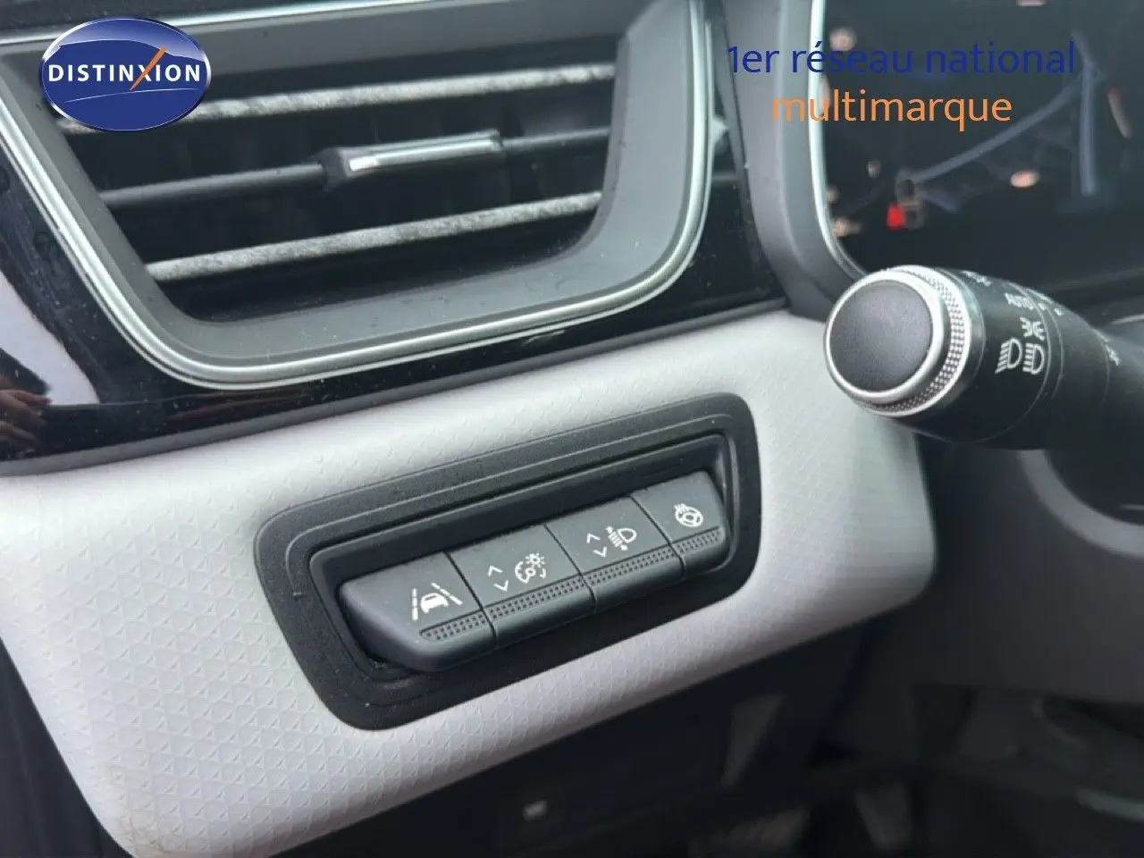 Gros plan sur les commandes d'assistance à la conduite dans l'habitacle du Renault Captur rouge flamme, côté gauche.