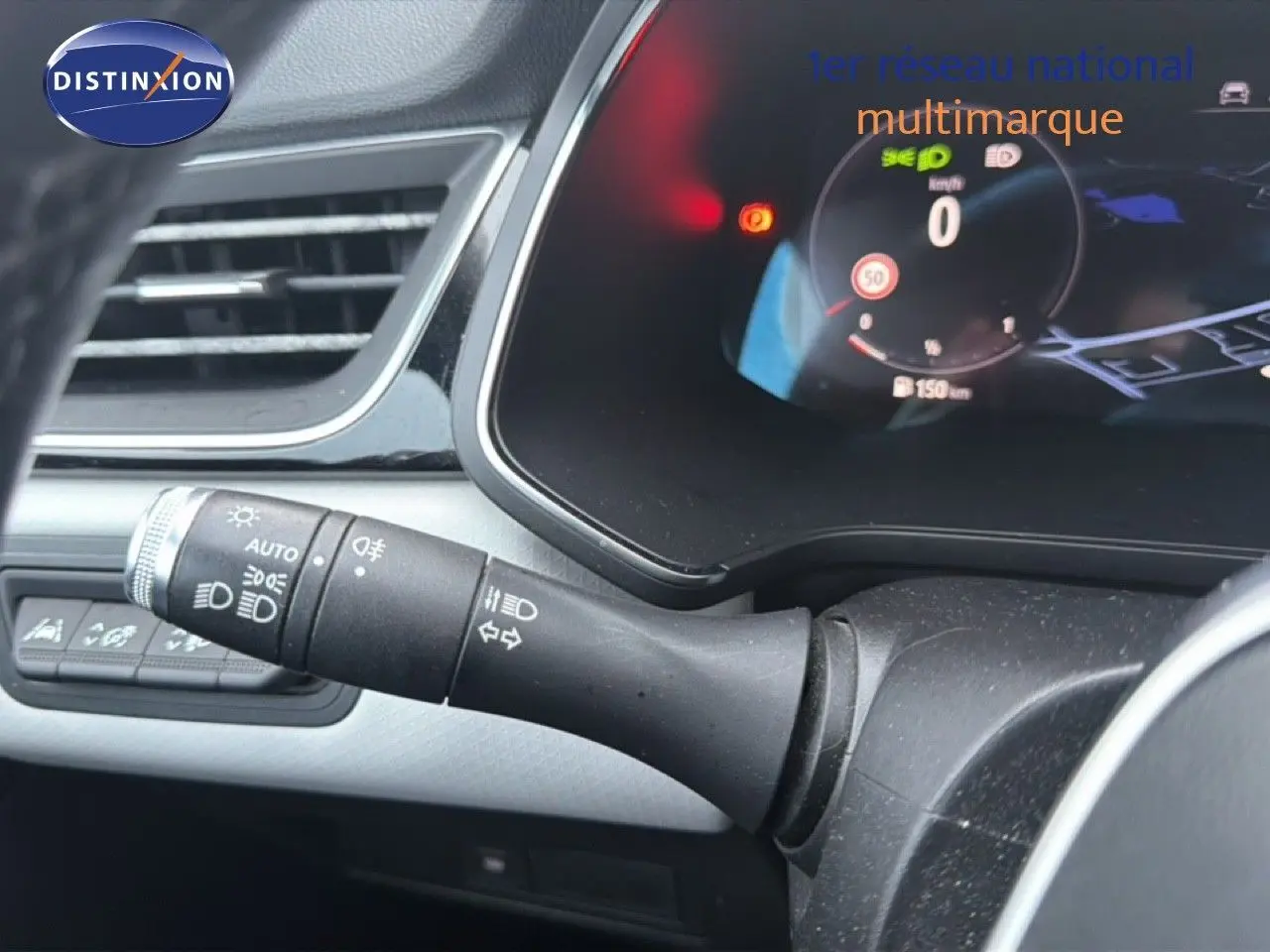 Gros plan sur la commande des phares et clignotants côté gauche du tableau de bord d’un Renault Captur rouge flamme 2020.