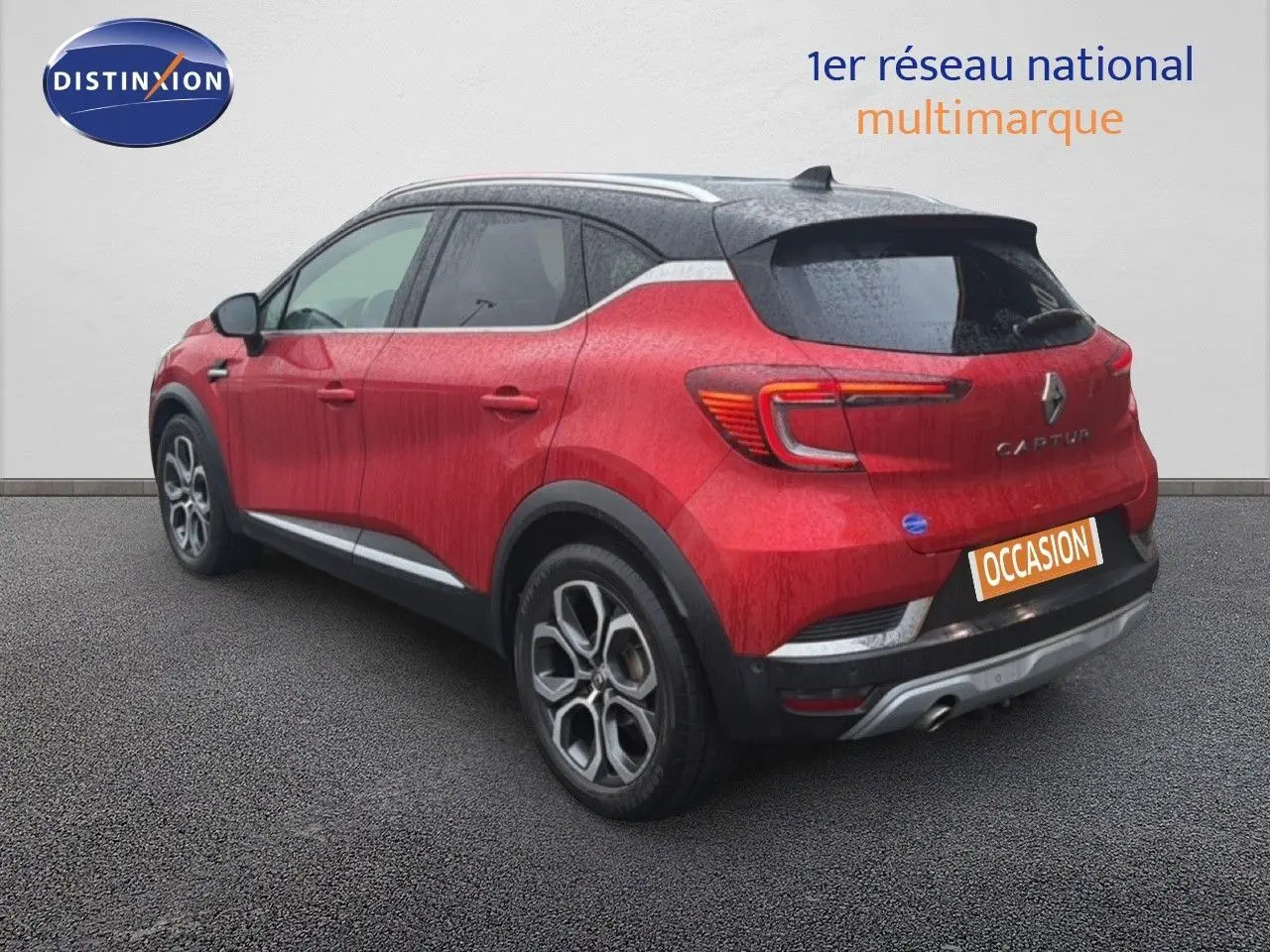Vue 3/4 arrière droite du Renault Captur rouge flamme avec toit noir et jantes alliage bicolores.