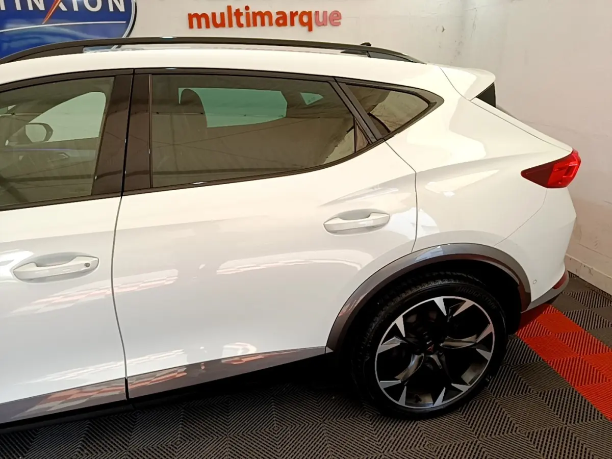 Vue latérale droite du CUPRA Formentor blanc, mettant en valeur la roue arrière noire à jantes stylisées et les lignes de caisse.