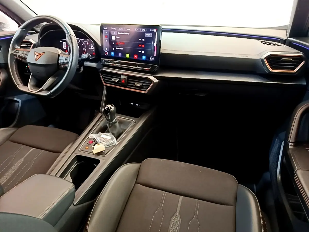 Intérieur avant du CUPRA Formentor 2023, tableau de bord noir avec écran tactile central et volant cuir alu.