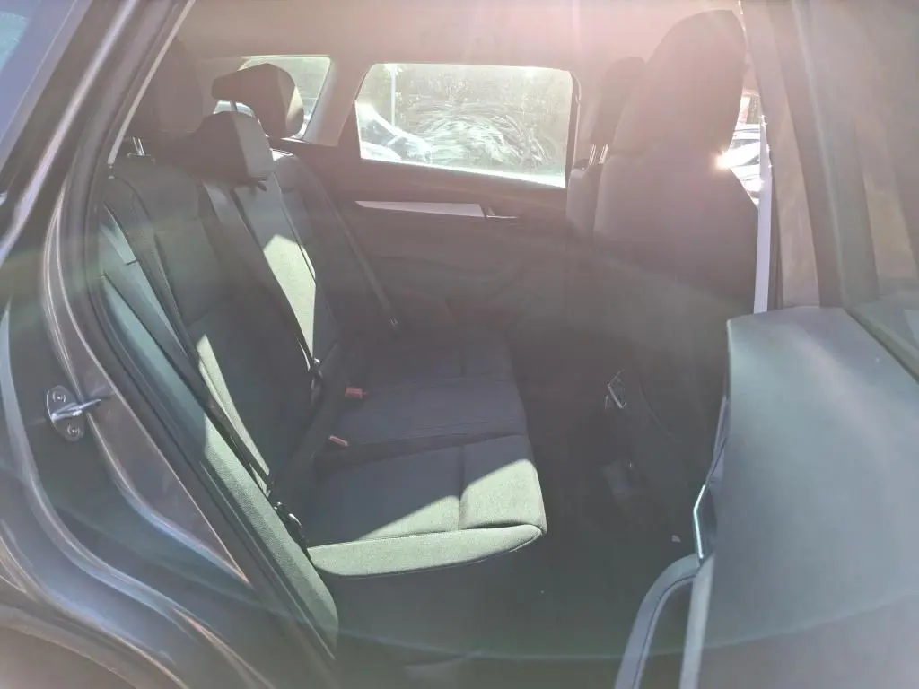 Gros plan sur la roue arrière droite d’un Skoda Karoq gris 2023 avec jante alu 17 pouces et carrosserie gris métallisé.