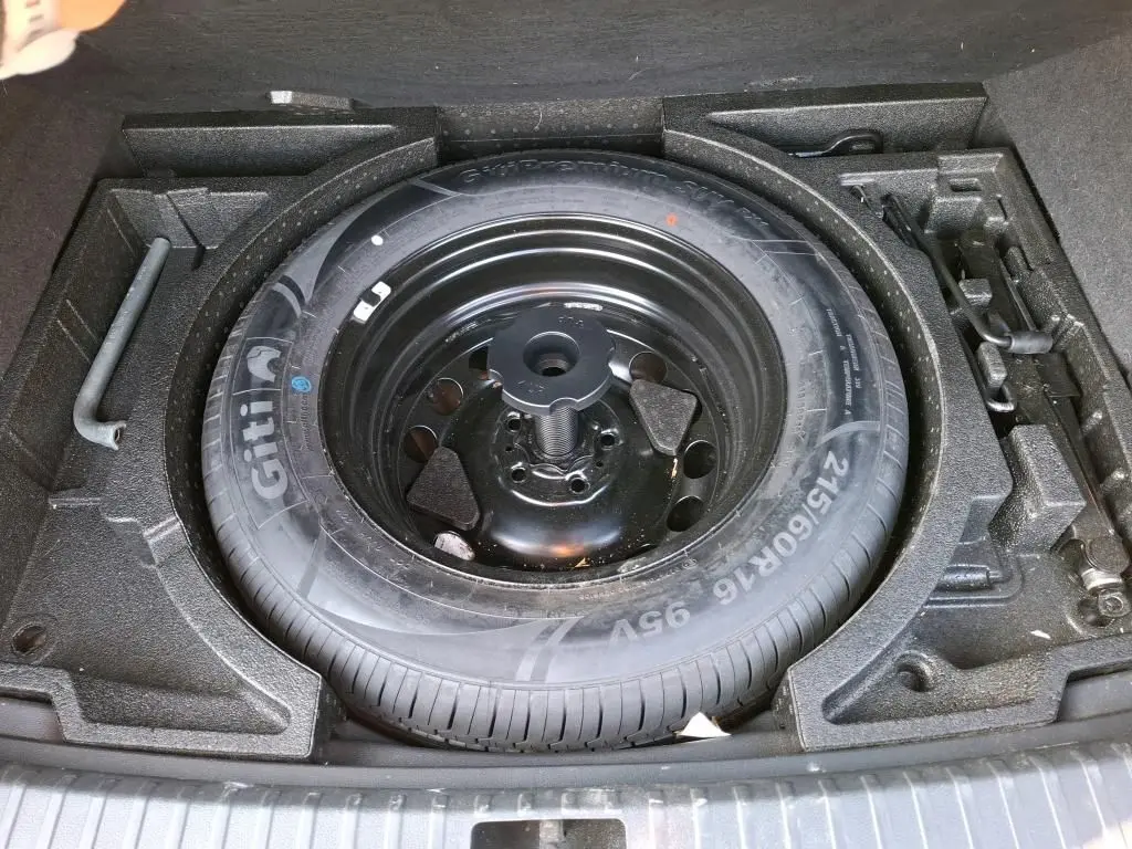 Vue intérieure côté conducteur de la Skoda Karoq 2023, sièges tissu noirs avec coutures contrastées et volant multifonctions.