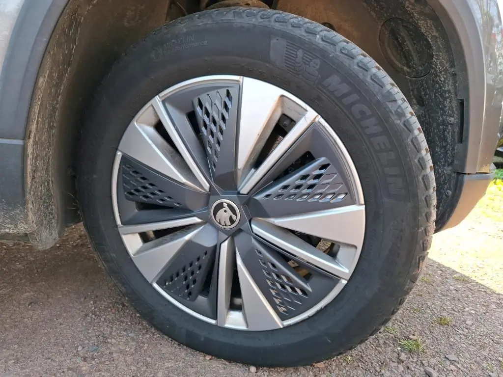 Vue arrière d'un Skoda Karoq gris 2023 avec feux LED et plaque Distinxion dans un garage intérieur.