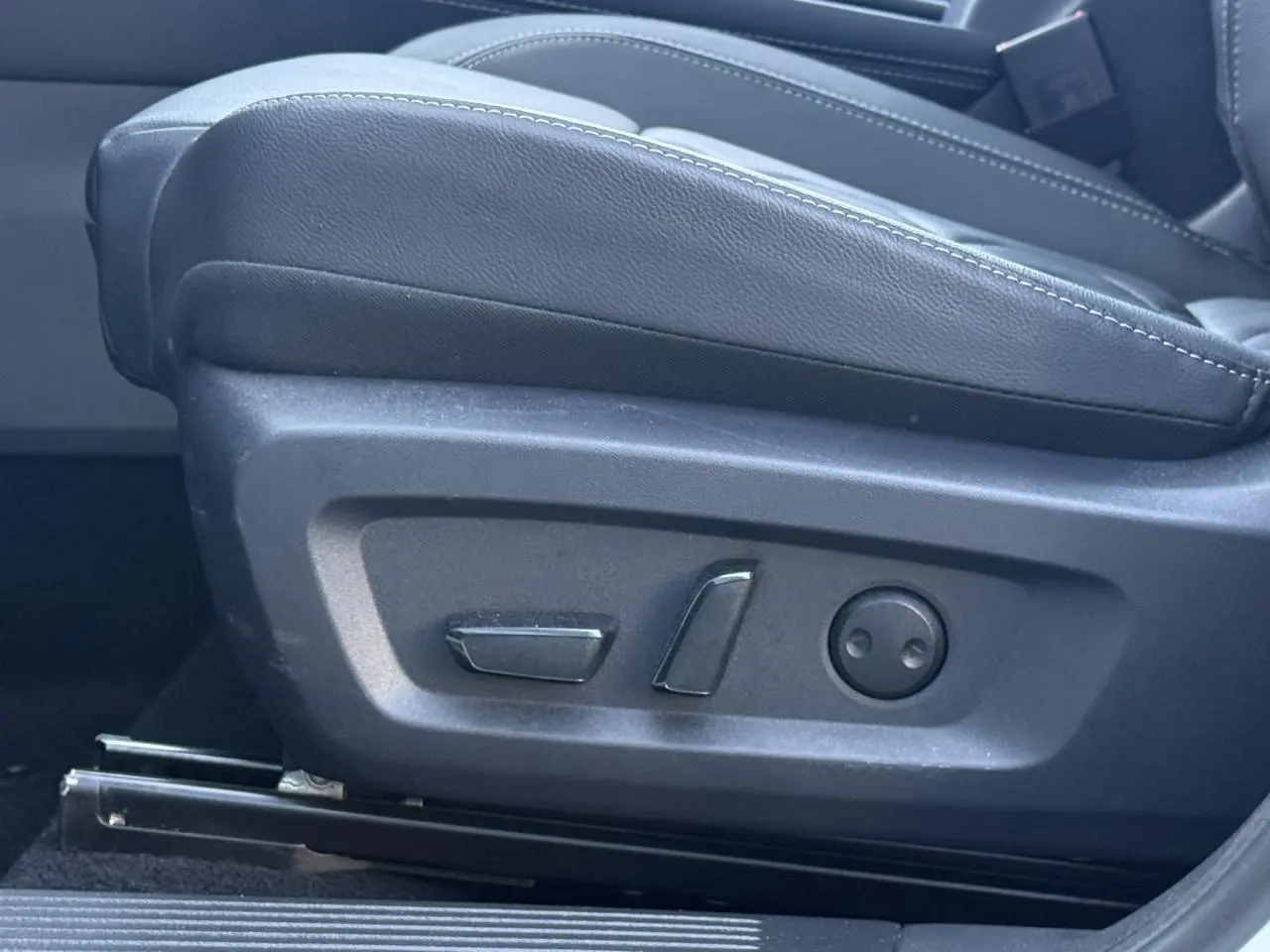 Détail des commandes électriques du siège avant droit en cuir noir du Nissan Qashqai blanc nacré 2025.