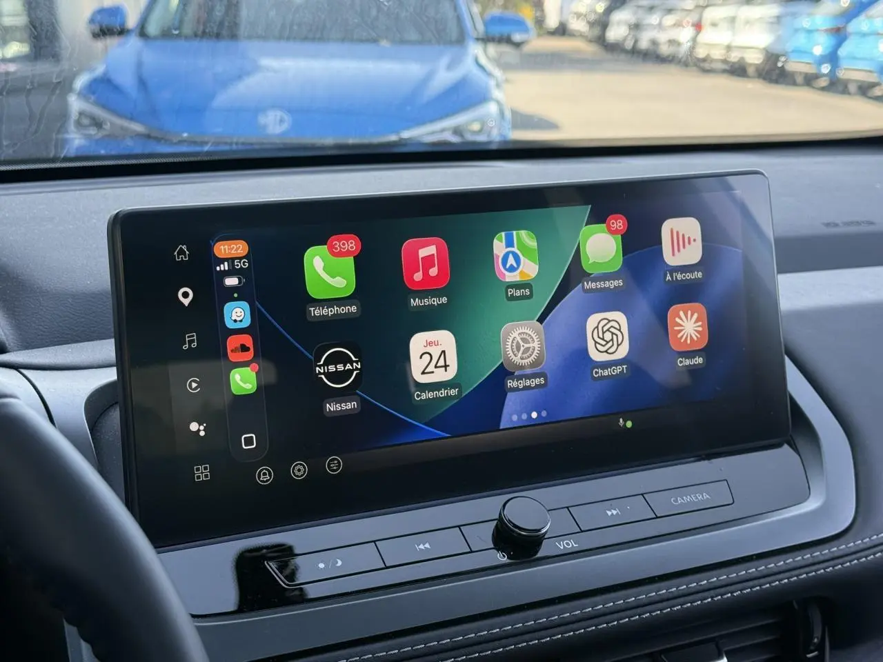 Vue intérieure du tableau de bord du Nissan Qashqai 2025 avec écran tactile large affichant Apple CarPlay.