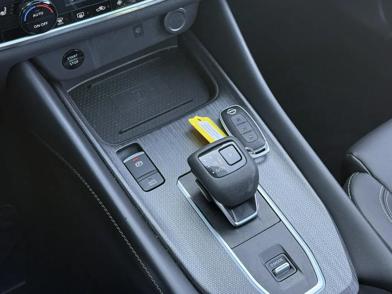 Vue rapprochée de la console centrale noire du Nissan Qashqai 2025 avec levier de vitesse automatique et clé électronique.