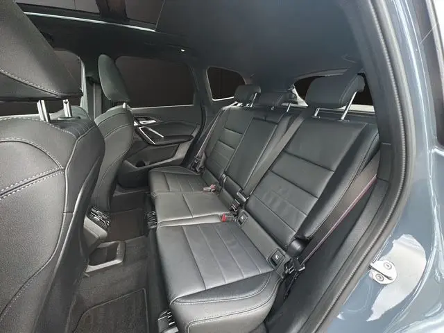 Vue côté droit de la banquette arrière en cuir noir Vernasca du BMW X1 Storm Bay avec vitres surteintées et sellerie M-Sport.