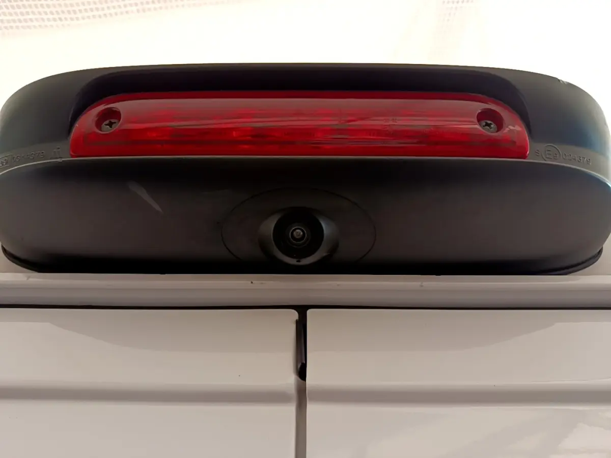 Gros plan sur la caméra de recul et le feu stop supérieur du Fiat Ducato Fourgon blanc, vue arrière haute.