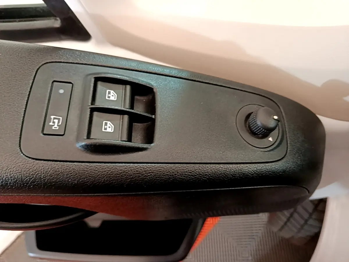 Gros plan sur les commandes de lève-vitres et réglage des rétroviseurs côté conducteur du Fiat Ducato Fourgon blanc.