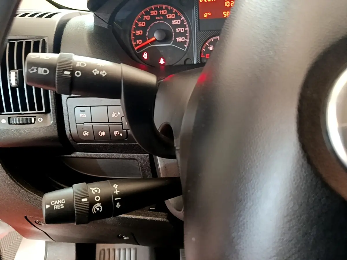 Gros plan sur le volant noir et les commandes de clignotants du tableau de bord du Fiat Ducato Fourgon blanc de 2021.