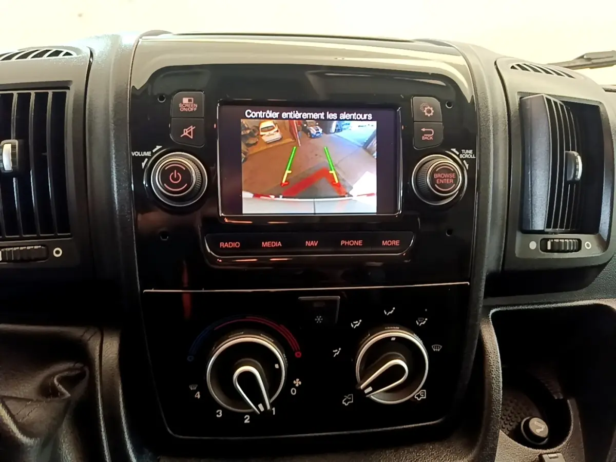 Vue rapprochée du tableau de bord noir du Fiat Ducato Fourgon 2021 avec écran tactile affichant la caméra de recul.