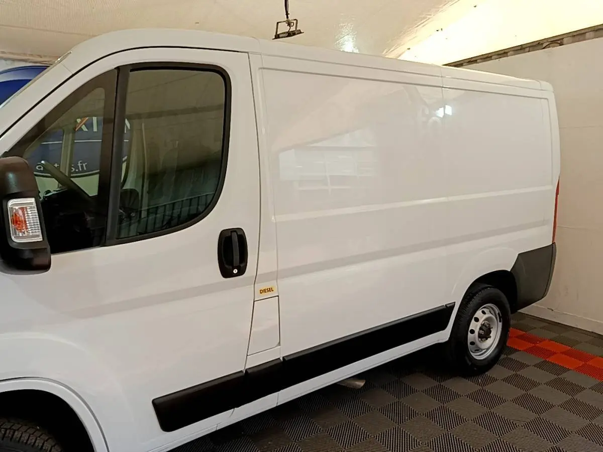 Vue de profil côté gauche d’un fourgon FIAT Ducato blanc 2021 avec bande noire latérale et marquage Diesel.