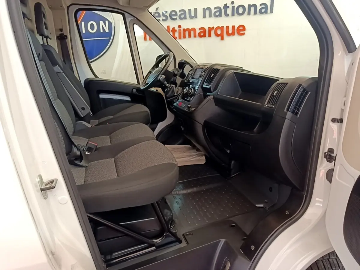 Intérieur du FIAT Ducato Fourgon blanc 2021 vu côté droit, montrant les sièges avant et le tableau de bord noir.
