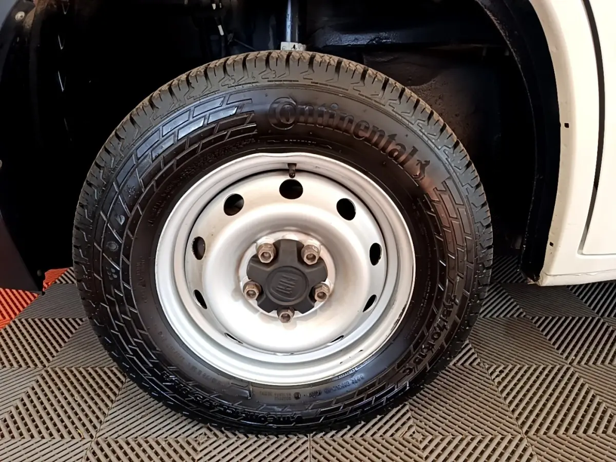 Gros plan sur la roue avant droite blanche d’un FIAT Ducato Fourgon 2021 avec pneu Continental noir.