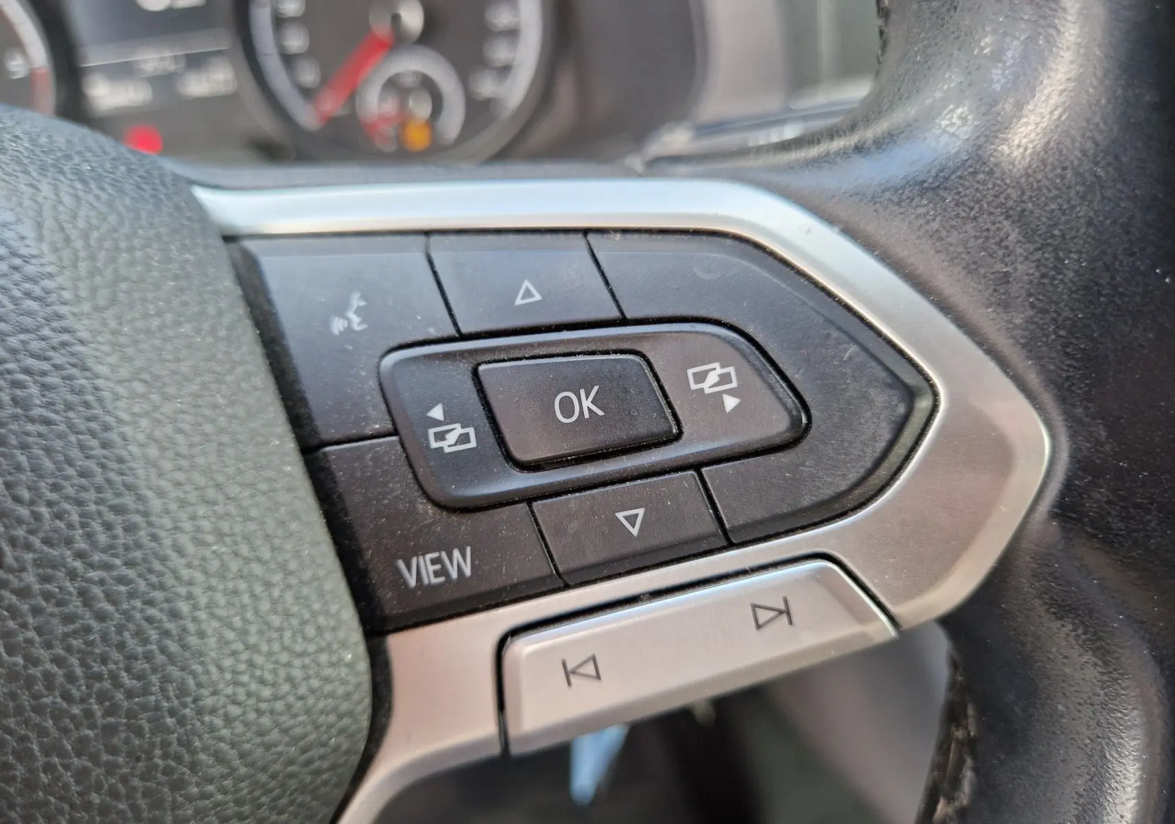 Gros plan sur les commandes multifonctions du volant du Volkswagen Transporter 2.0 TDi Business Line noir de 2020.