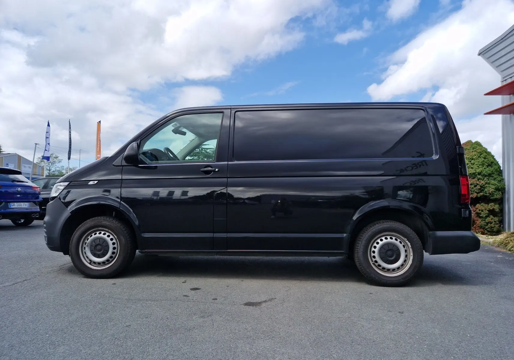 Vue latérale côté gauche d'un Volkswagen Transporter noir L1H1 finition Business Line, profil utilitaire épuré.