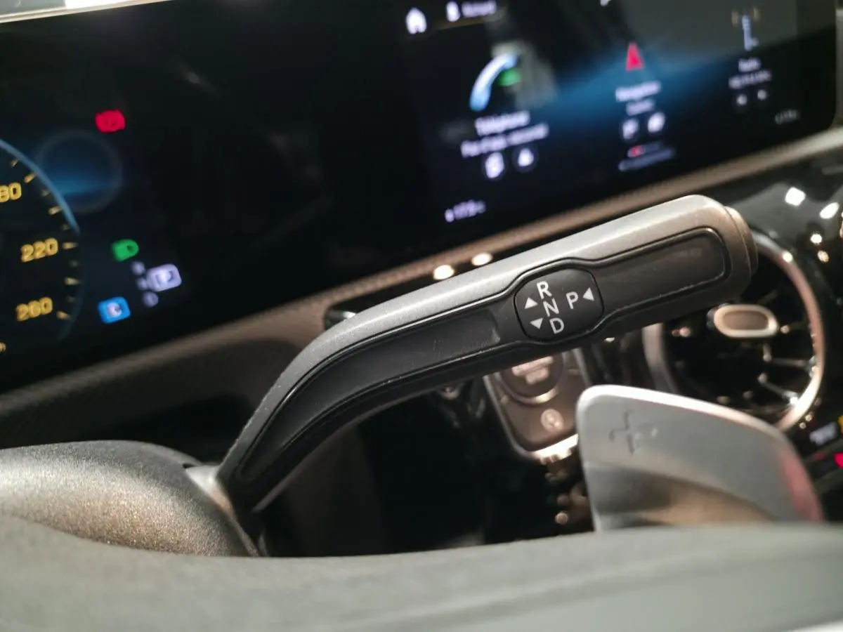 Gros plan sur la commande de boîte automatique à droite du volant dans le cockpit noir du Mercedes Classe A gris AMG Line 2019.