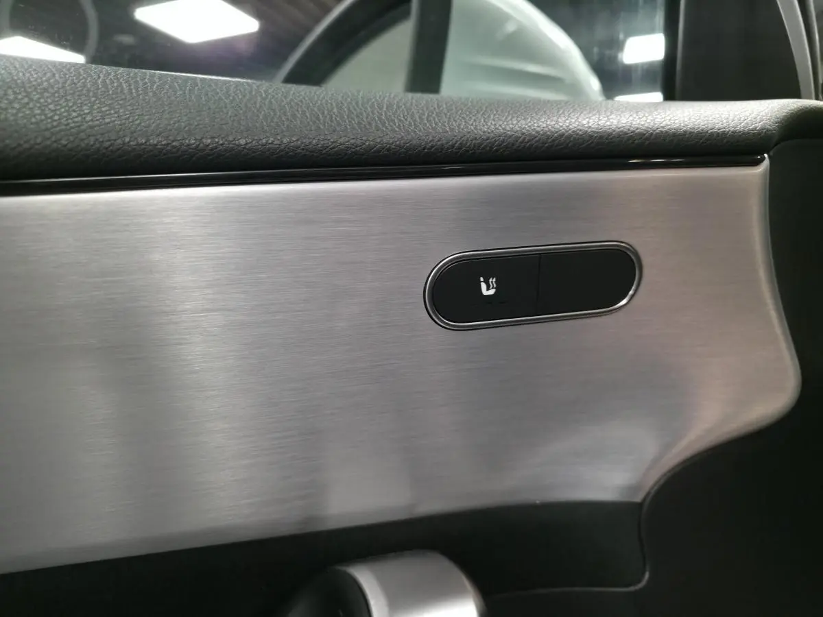 Détail du bouton de siège chauffant sur la garniture intérieure argent brossé d'une Mercedes Classe A AMG Line 2019.