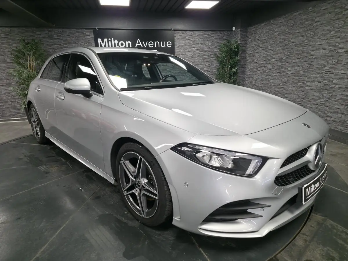 Vue 3/4 avant droite d'une Mercedes Classe A gris métallisé avec jantes AMG et calandre diamantée.