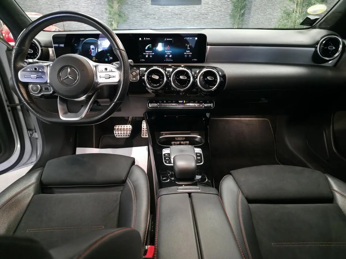 Vue intérieure avant de la Mercedes Classe A A 200 d AMG Line 2019 avec tableau de bord numérique et sièges sport noirs.