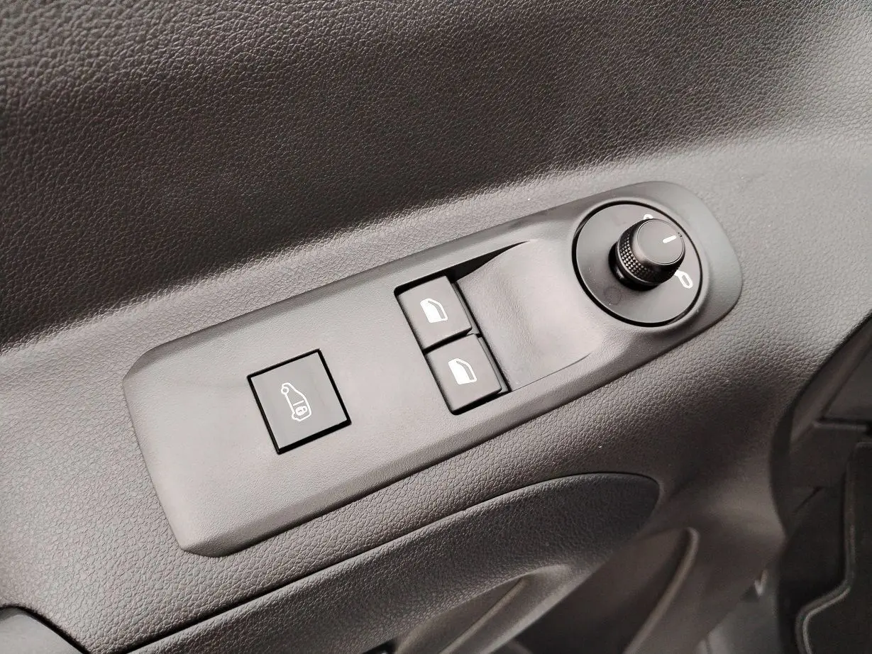 Gros plan sur les commandes de réglage des rétroviseurs et vitres côté conducteur du Peugeot Partner Fourgon blanc Icy 2025.