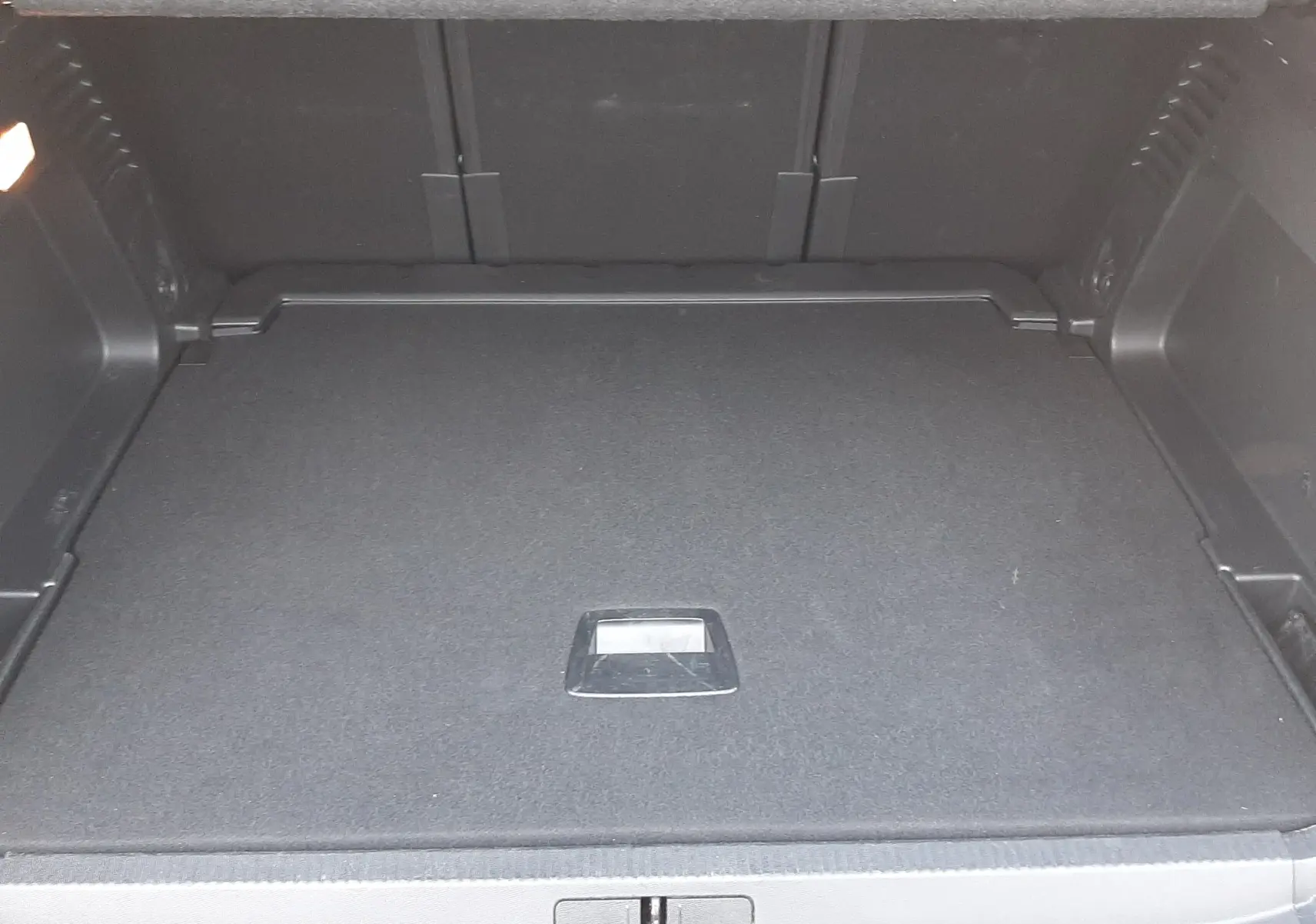 Coffre ouvert vu de l'arrière d'un Citroën C5 Aircross noir Perla Nera, montrant un espace de chargement propre et vide.