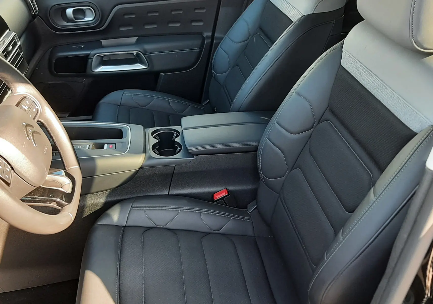 Vue intérieure côté avant droit du Citroën C5 Aircross 2024, sièges en cuir noir et gris avec console centrale.