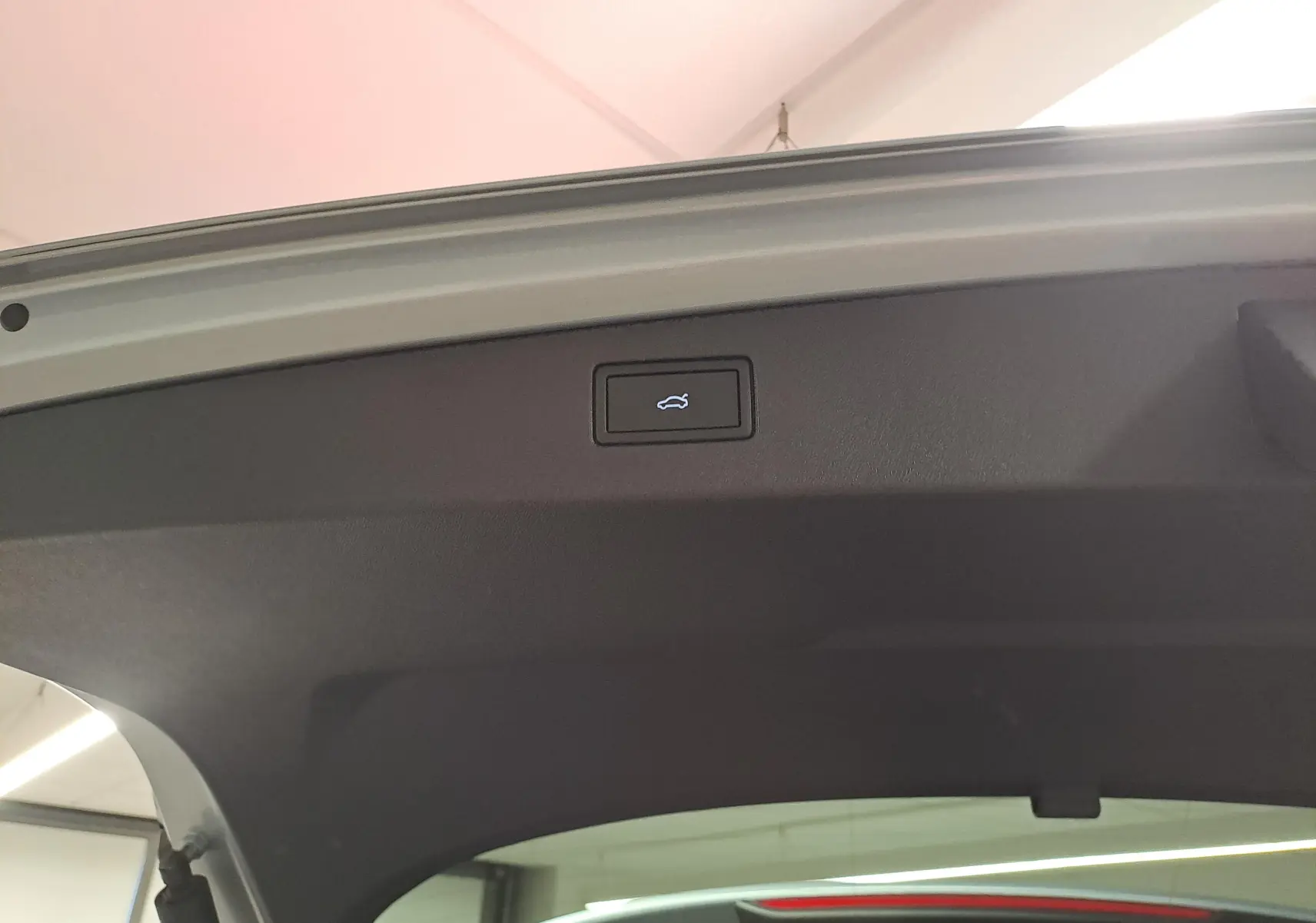 Bouton d'ouverture électrique du coffre sur la trappe arrière d'un Volkswagen Tiguan 2.0 TDI argent Dolomite.