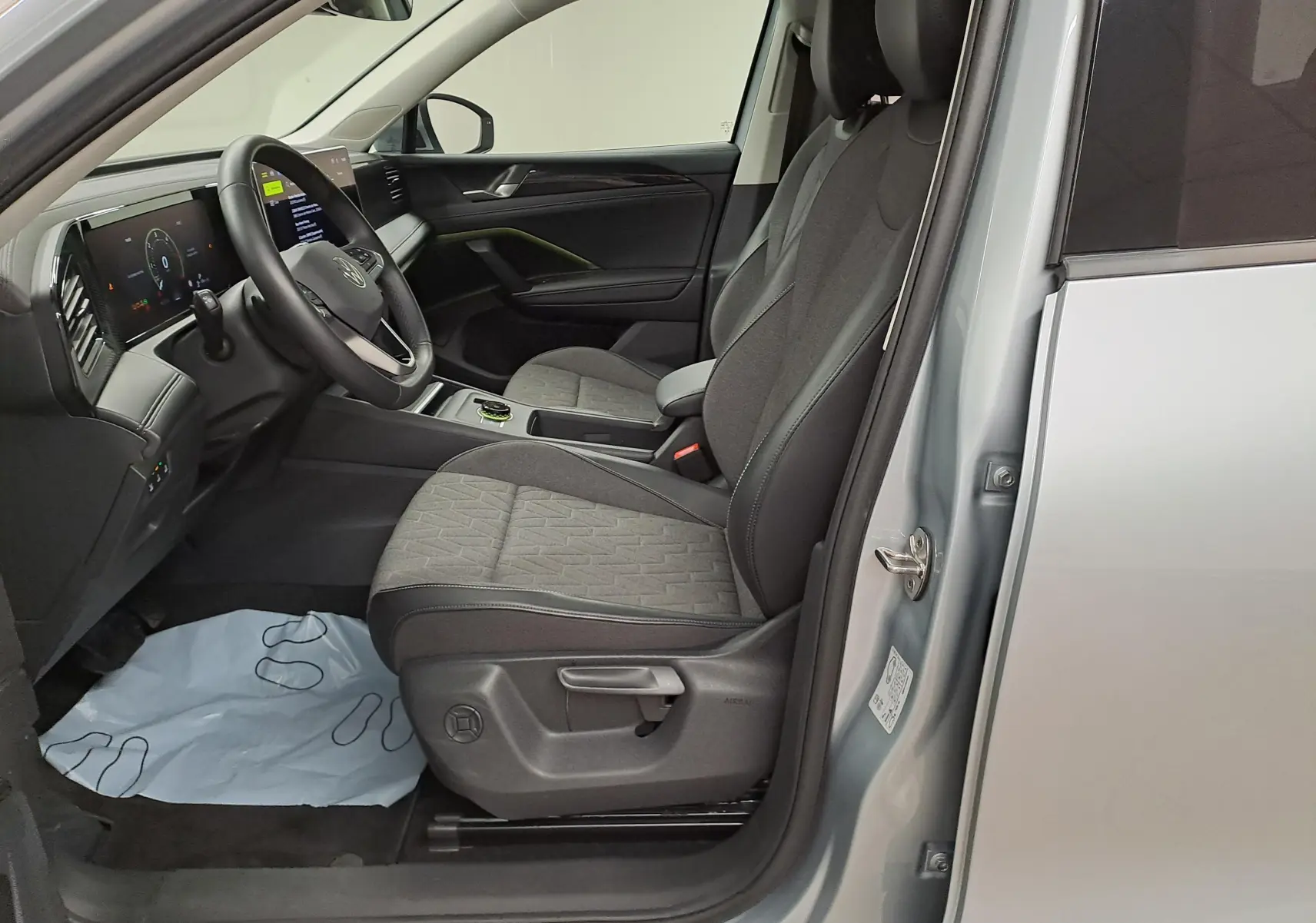 Vue intérieure côté conducteur du Volkswagen Tiguan 2025 argent Dolomite, sièges tissu gris et tableau de bord moderne.
