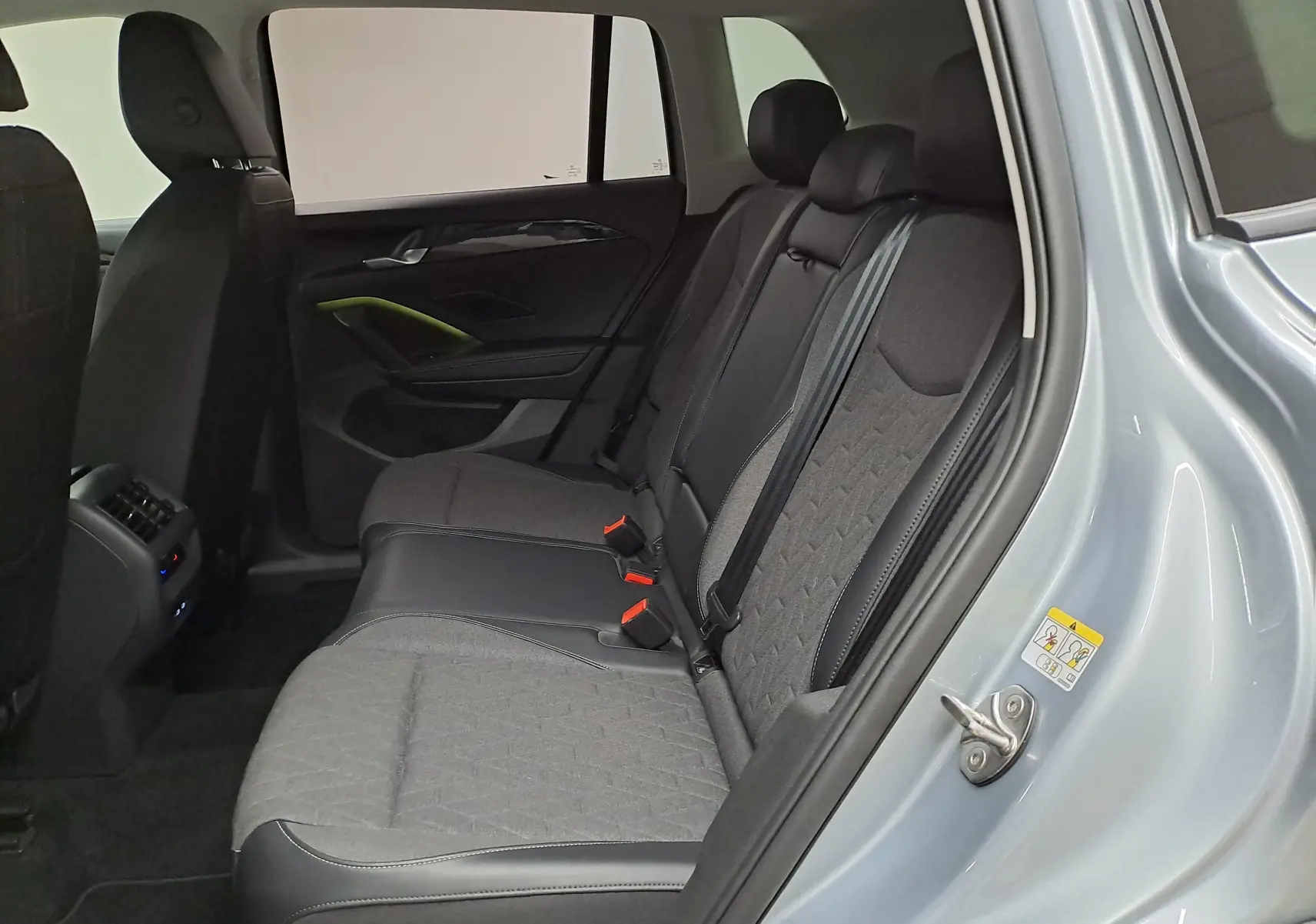 Vue intérieure côté droit des sièges arrière du Volkswagen Tiguan 2025 en Argent Dolomite avec sellerie tissu et cuir.