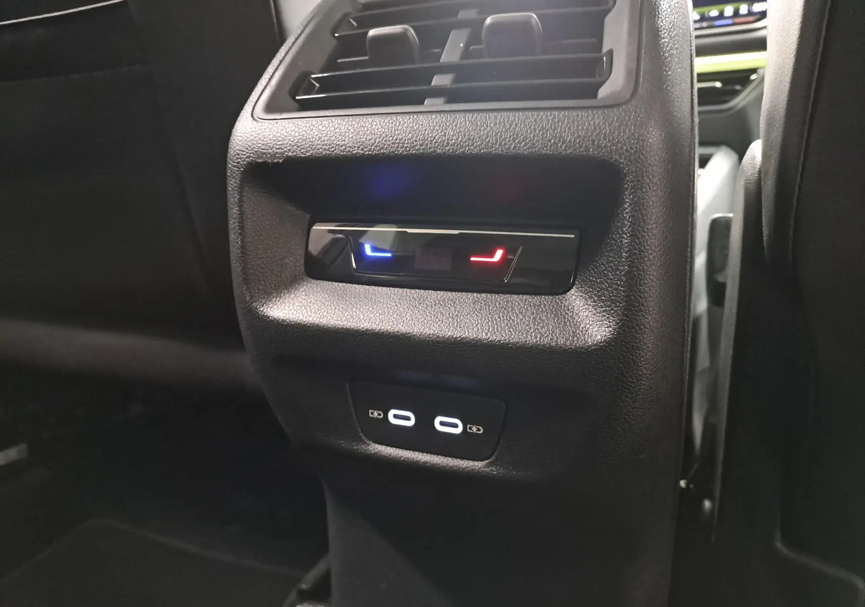 Vue rapprochée de la console arrière du Volkswagen Tiguan 2025, avec commandes de climatisation et ports USB visibles.